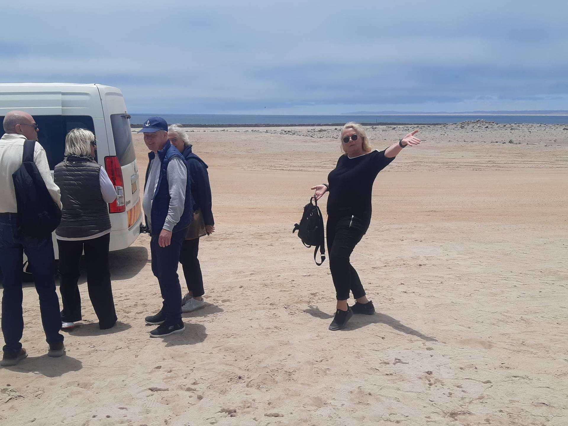 Tourists stepping out of the SEGEN minibus onto a coastal beach stop