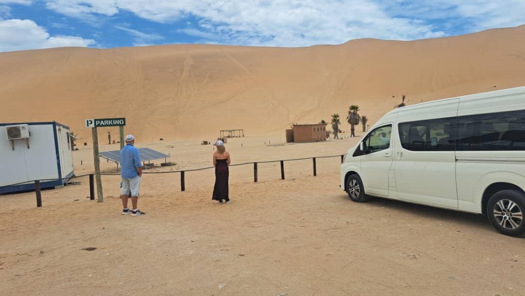 Tourists arriving at the towering Namibian sand dunes with SEGEN Tours minibus