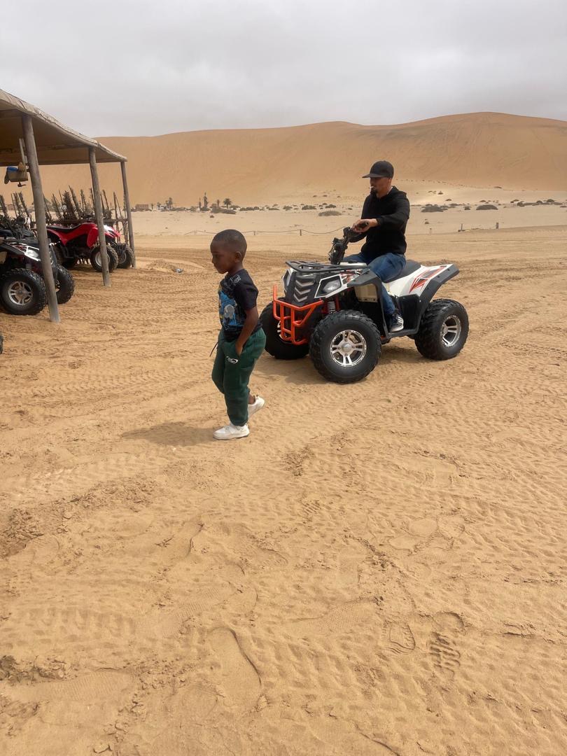 Quad bikes lined up at the desert dune base ready for adventure