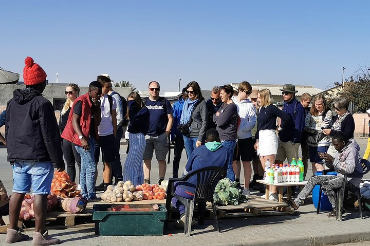 Tour group browsing fresh produce at a township market during the Market Tour