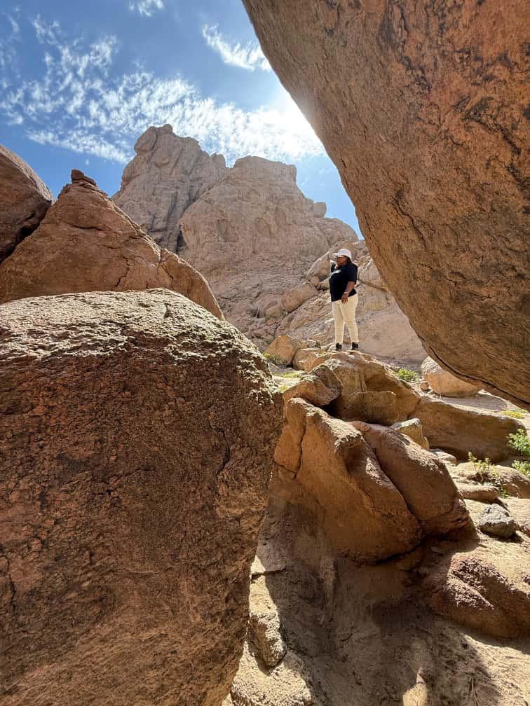 Guide exploring a dramatic rock canyon passage at Spitzkoppe